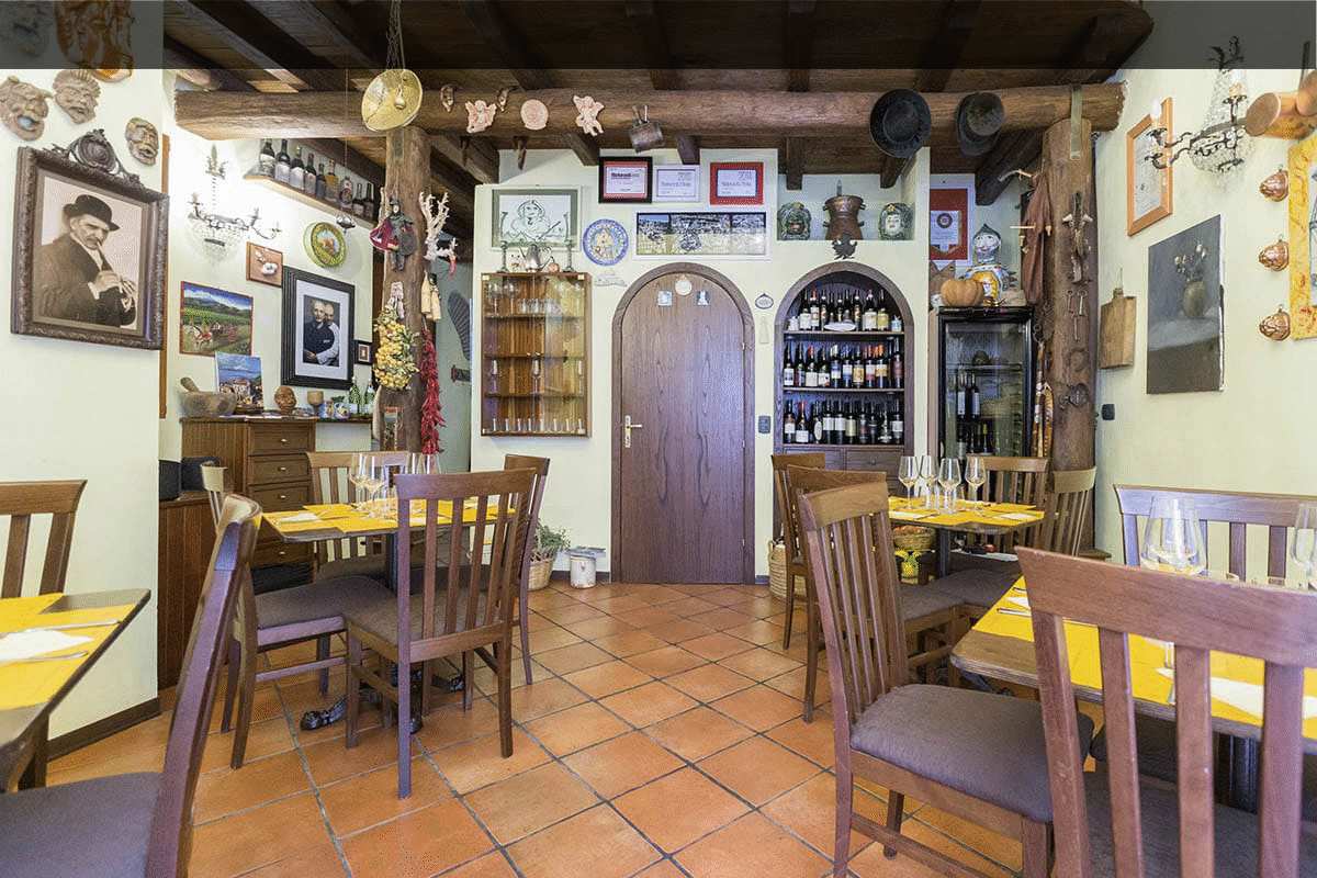 La sala da pranzo a piano terra della Trattoria Tischi Toschi a Taormina, quasi un museo della tradizione siciliana. Pochi coperti per una qualità superiore.